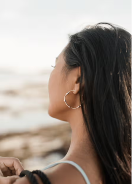 woman wearing gold seaweed earring
