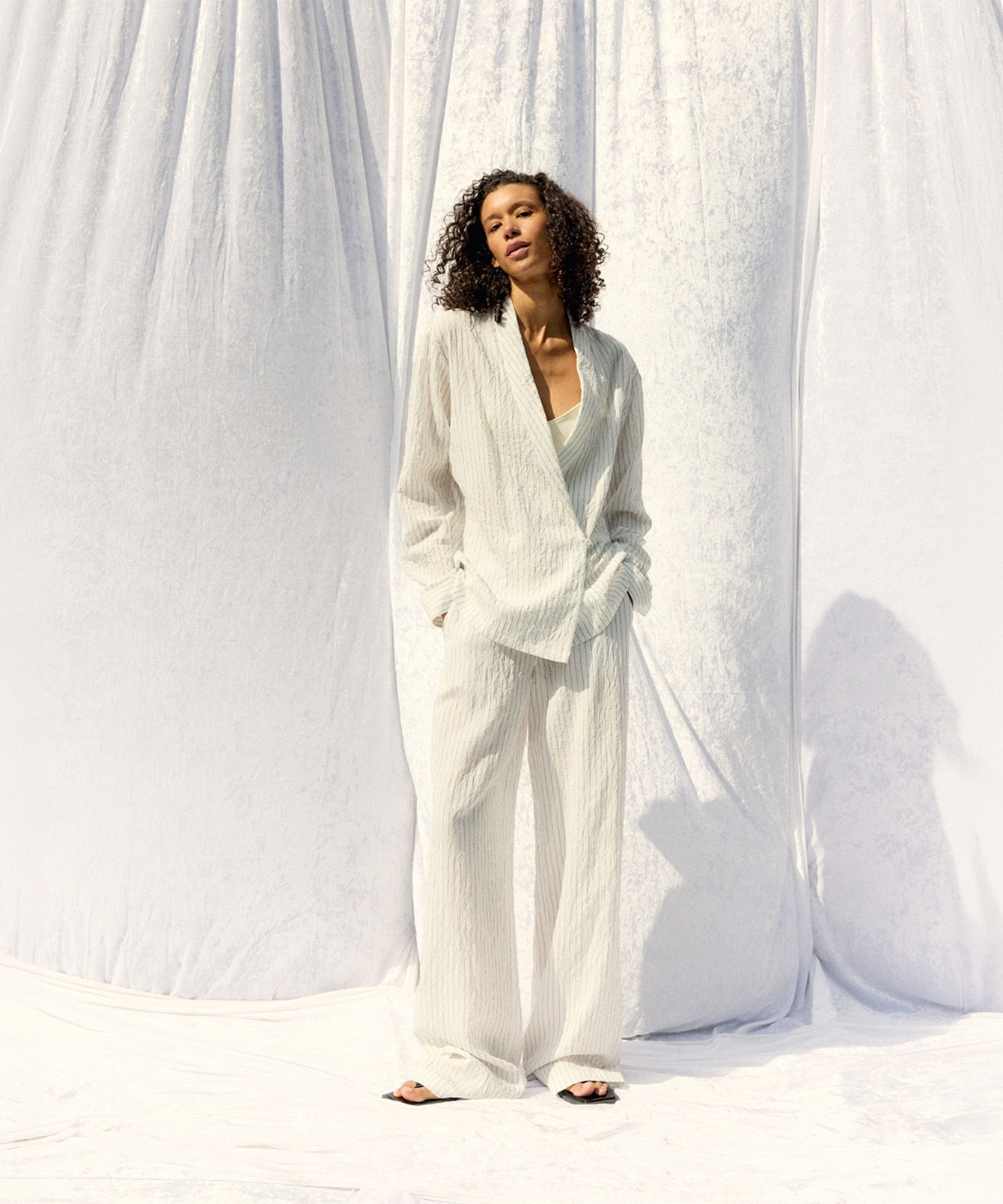 Person in white outfit standing against a white backdrop. image redirects to summer 2026 collection page