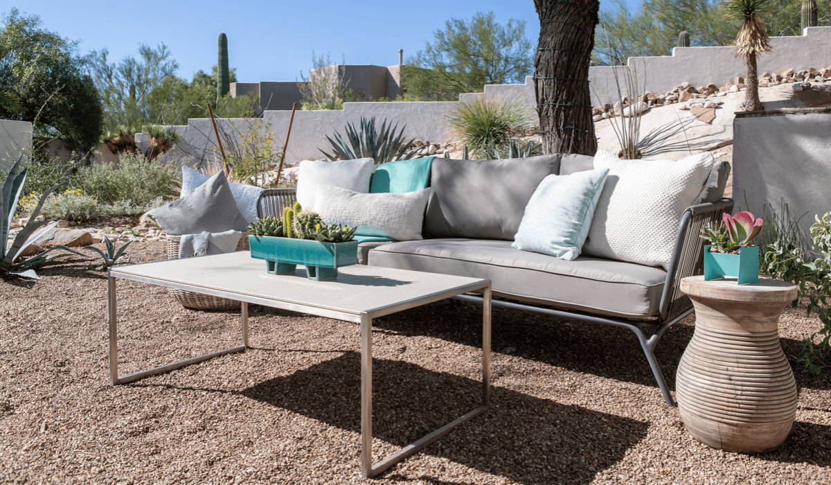 A desert patio lounge area with outdoor coffee table and sofa.