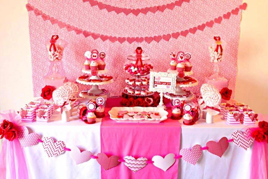 valentine's day table setting with candy and cakes.