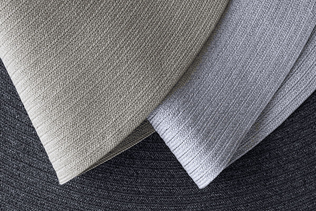 Close-up of layered neutral flatweave outdoor rugs in different shades, highlighting texture, weave, and versatile patio-friendly colors for outdoor use.