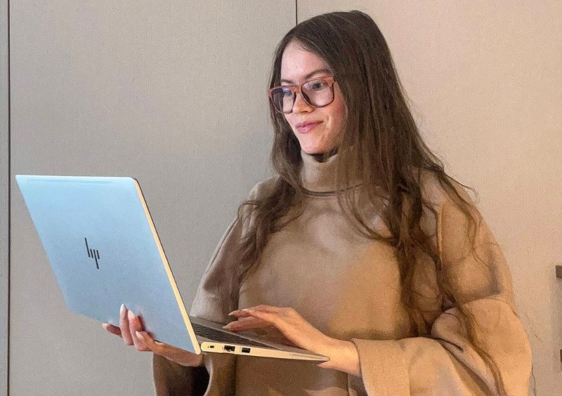 woman wearing Brave Rose migraine glasses while working on laptop