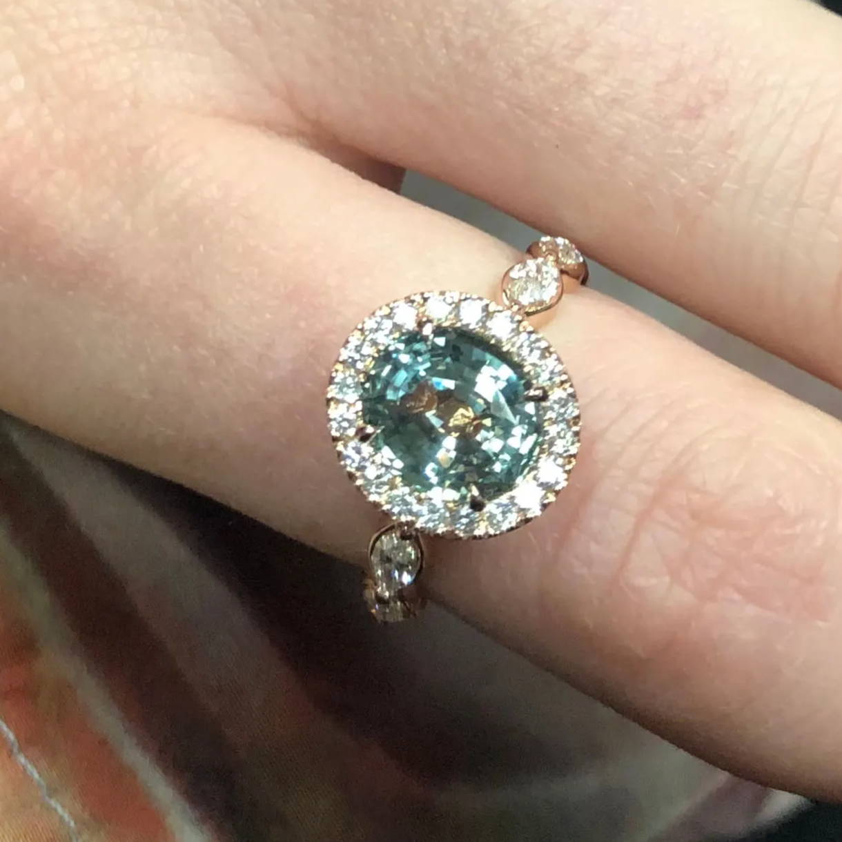 green sapphire engagement ring on hand close up