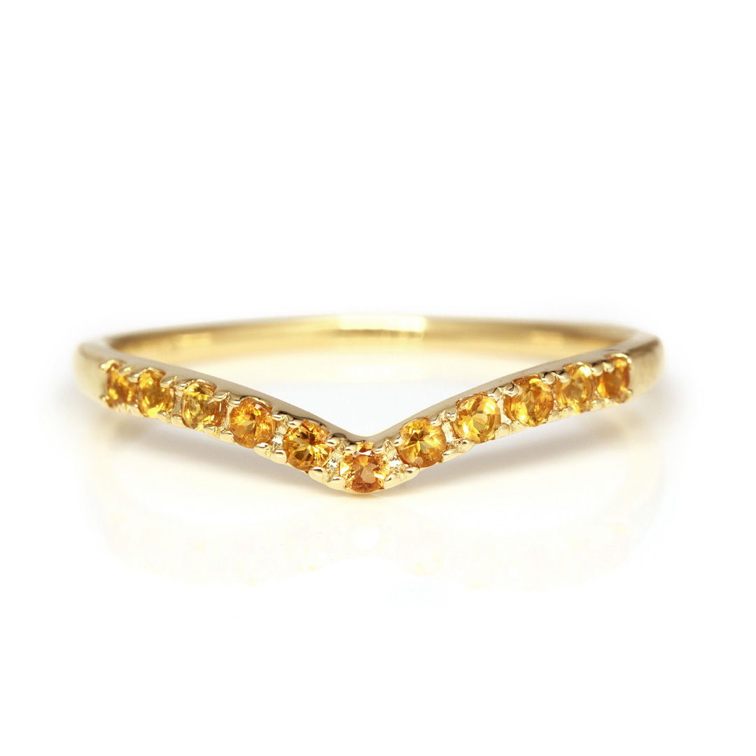 Gold chevron ring with yellow gemstones.
