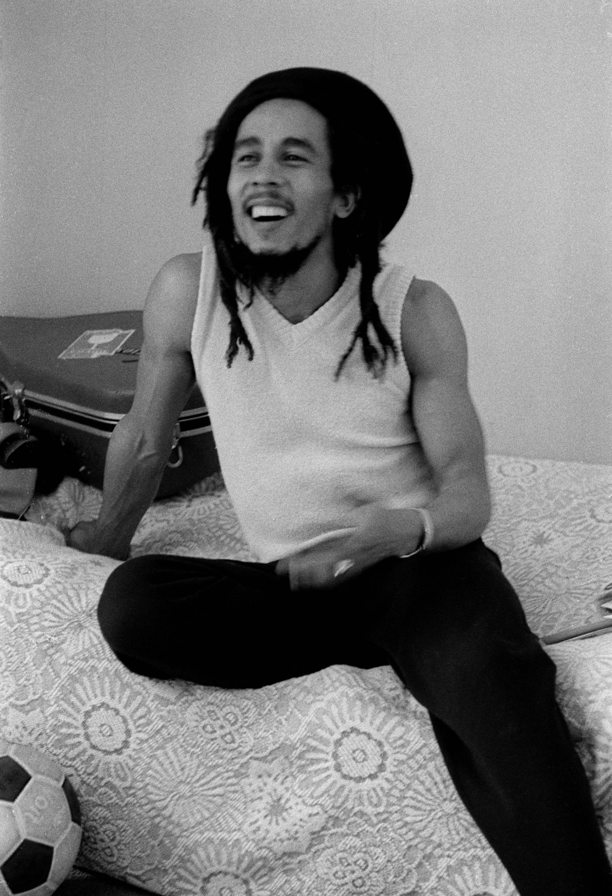 Bob Marley sitting on a bed