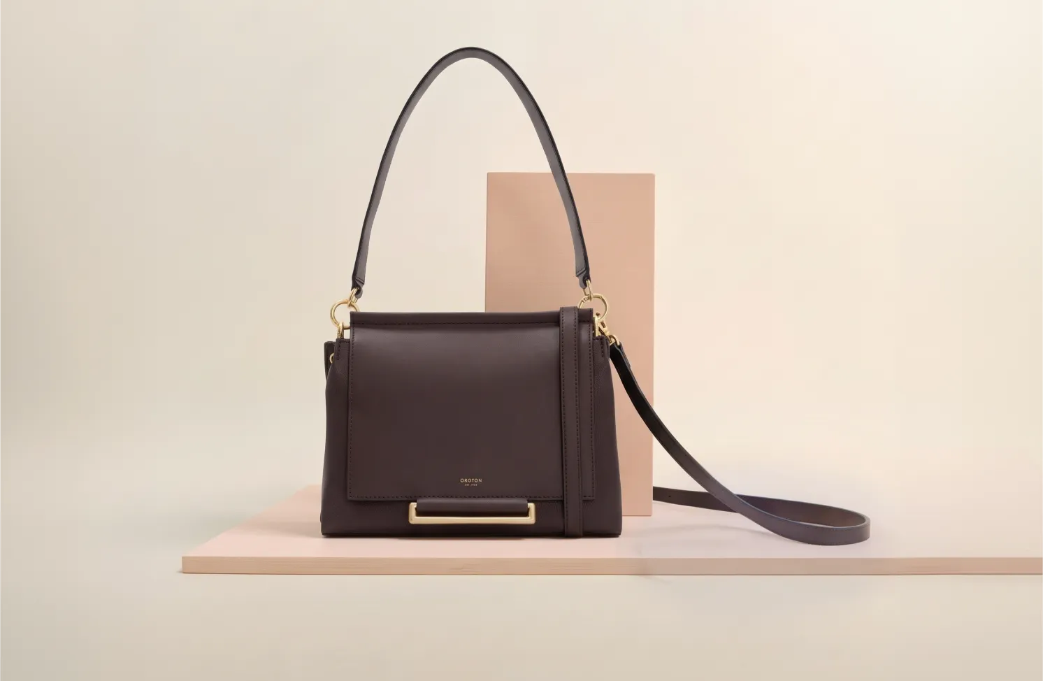 A stylish brown handbag displayed on a soft background.