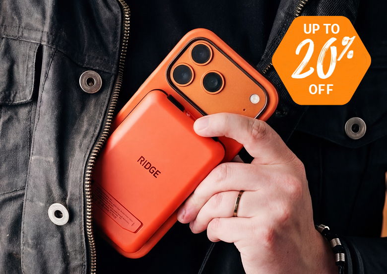 Person holding an orange phone and accessory, with a discount tag.