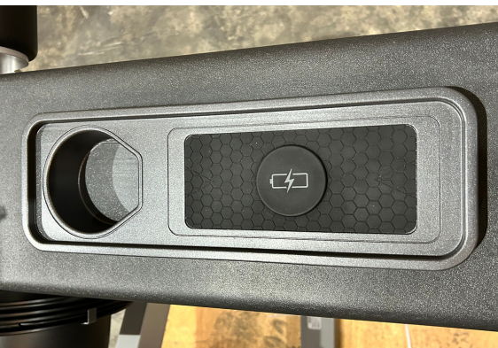 Close-up of a black surface with a circular cutout and button.