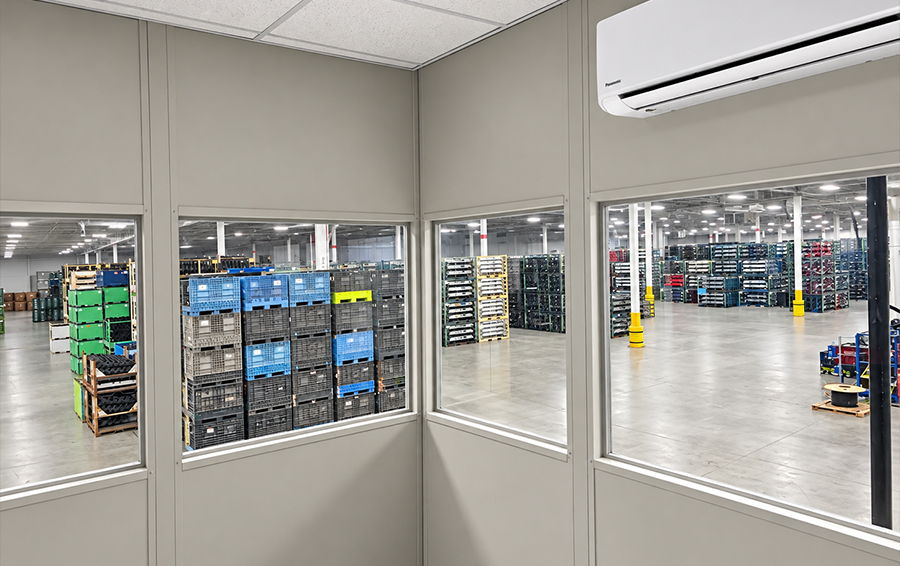 Interior view of a warehouse with storage containers and windows.