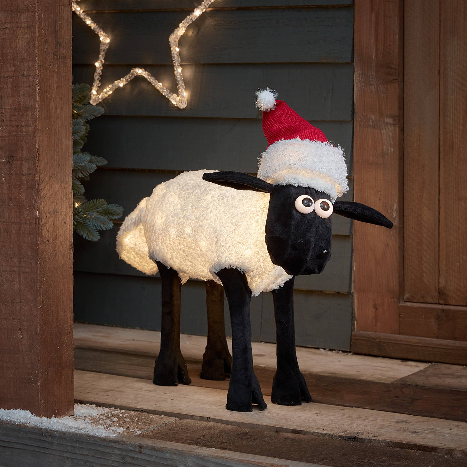 Shaun the Sheep™ standing on a seasonal porch with star lights  and lit by warm white LEDs