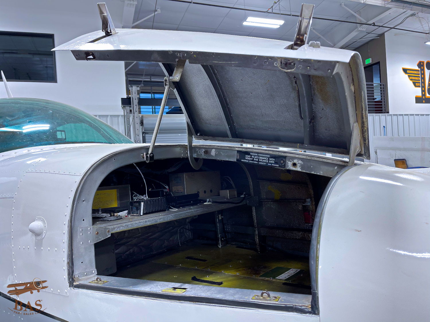 Open aircraft compartment revealing tools and equipment inside.