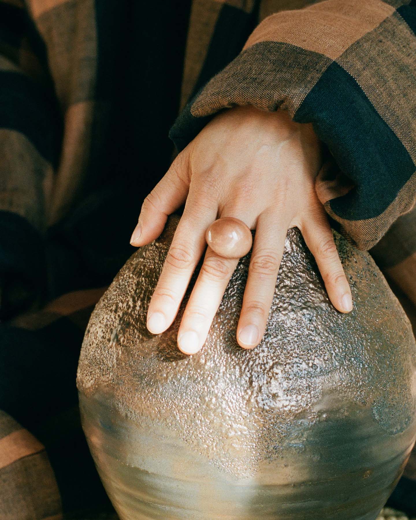 Close up of a hand wearing a pink acrylic ring.