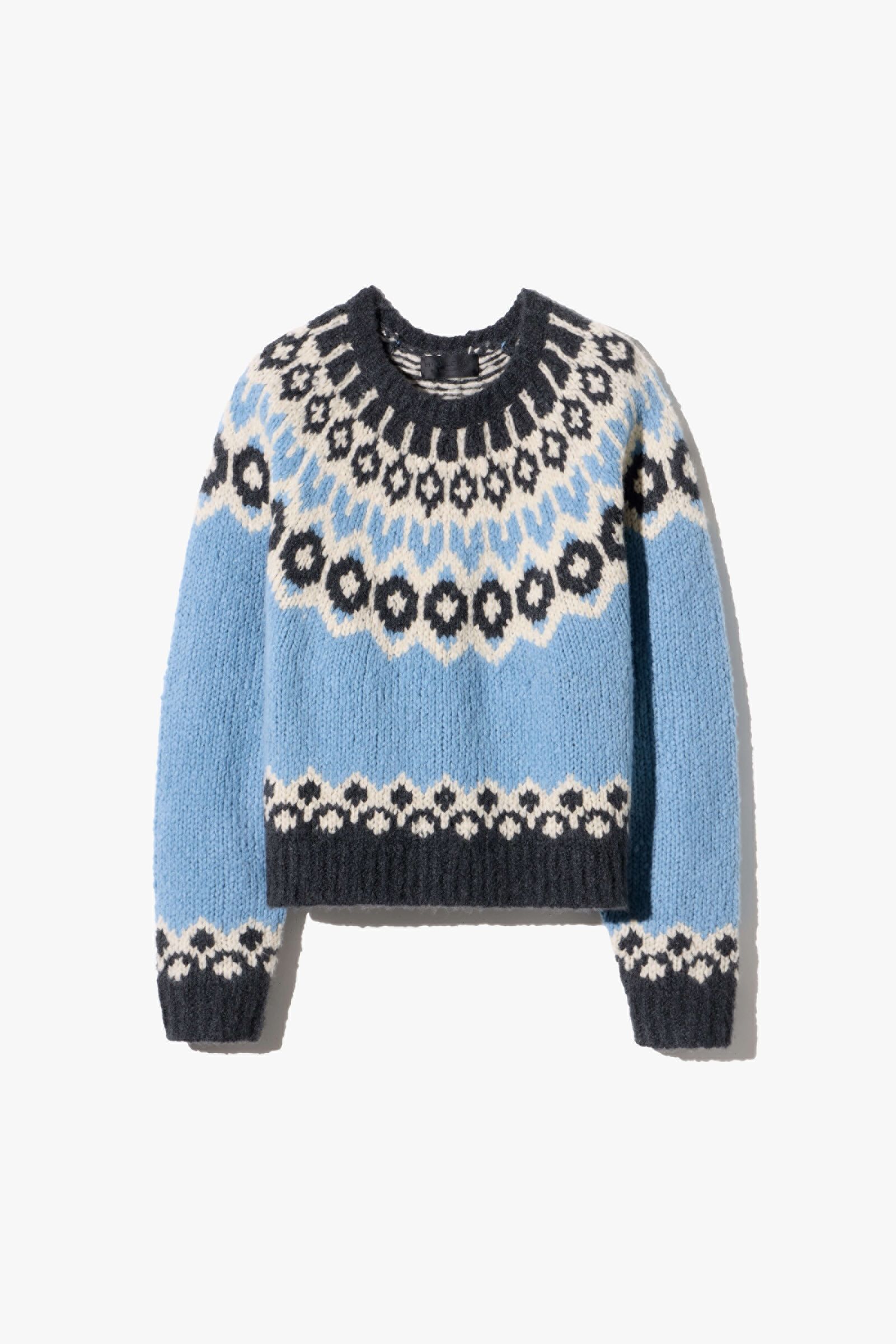 Knitted sweater with blue, black, and white geometric patterns.