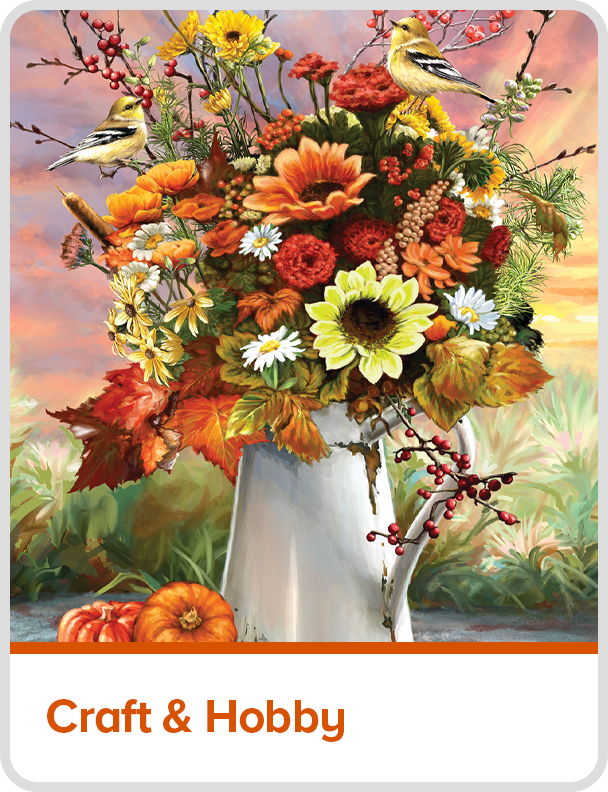A vibrant bouquet of flowers in a white pitcher with autumn leaves.