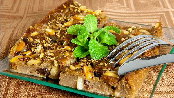 castagnaccio cake filled with fennel seed and brown dense cake with a sprig of mint on top