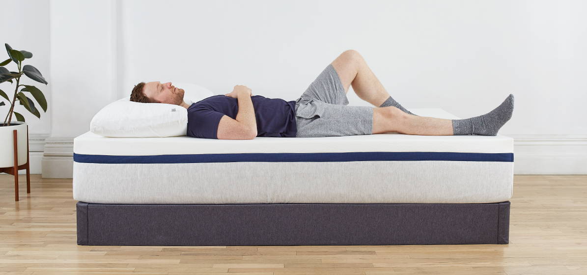 Man laying on his back on Helix Midnight mattress on top of foundation