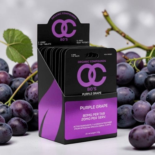 Purple grape flavored hair styling product displayed among grapes.