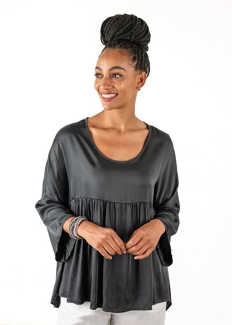A model wearing a dark grey blouse with a scooping neckline, 3/4 loose sleeves and peplum skirt