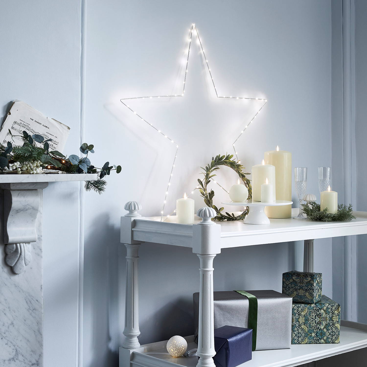 Oversized Osby star and TruGlow candles with festive wreaths styled on side table