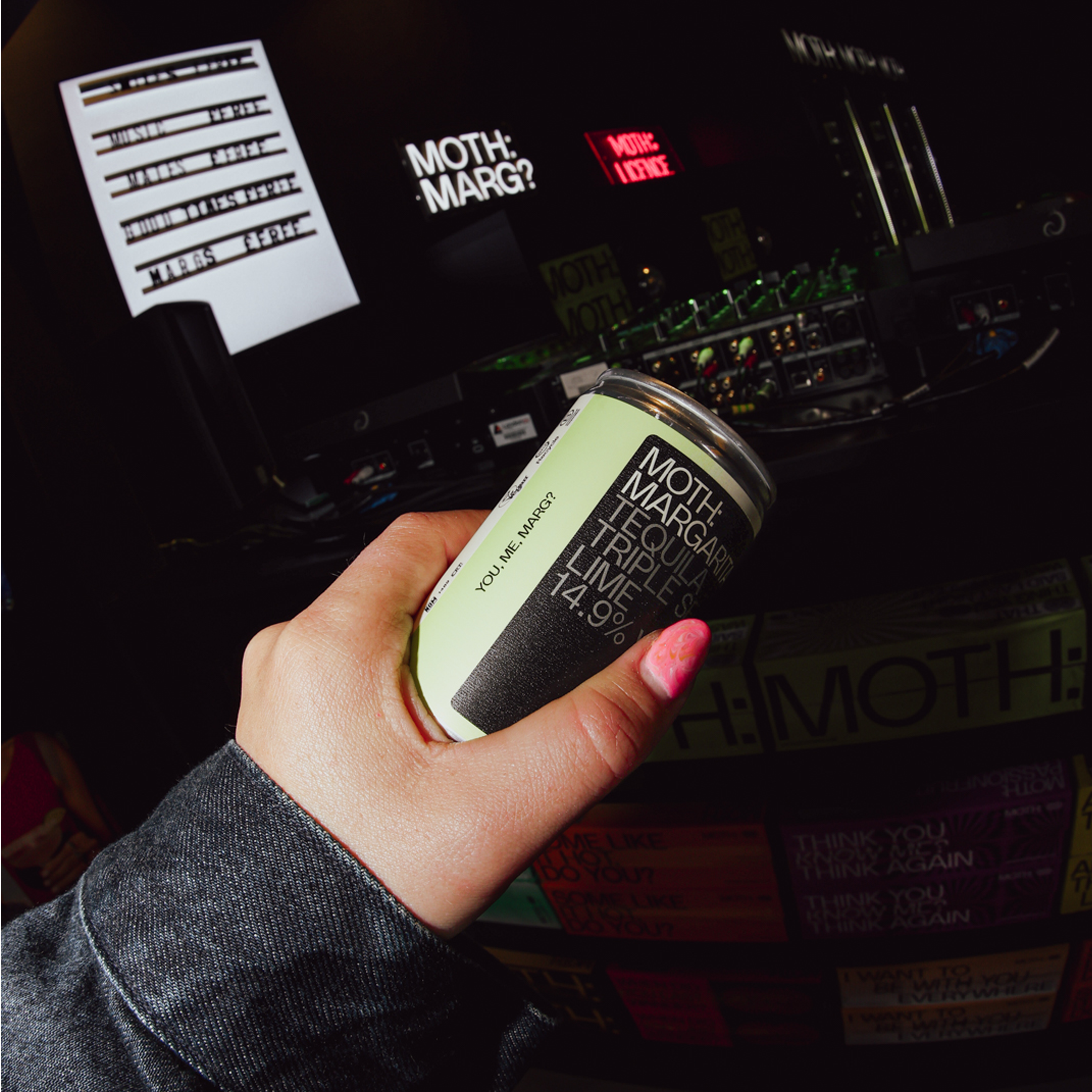 Person holding a can in front of a vending machine.