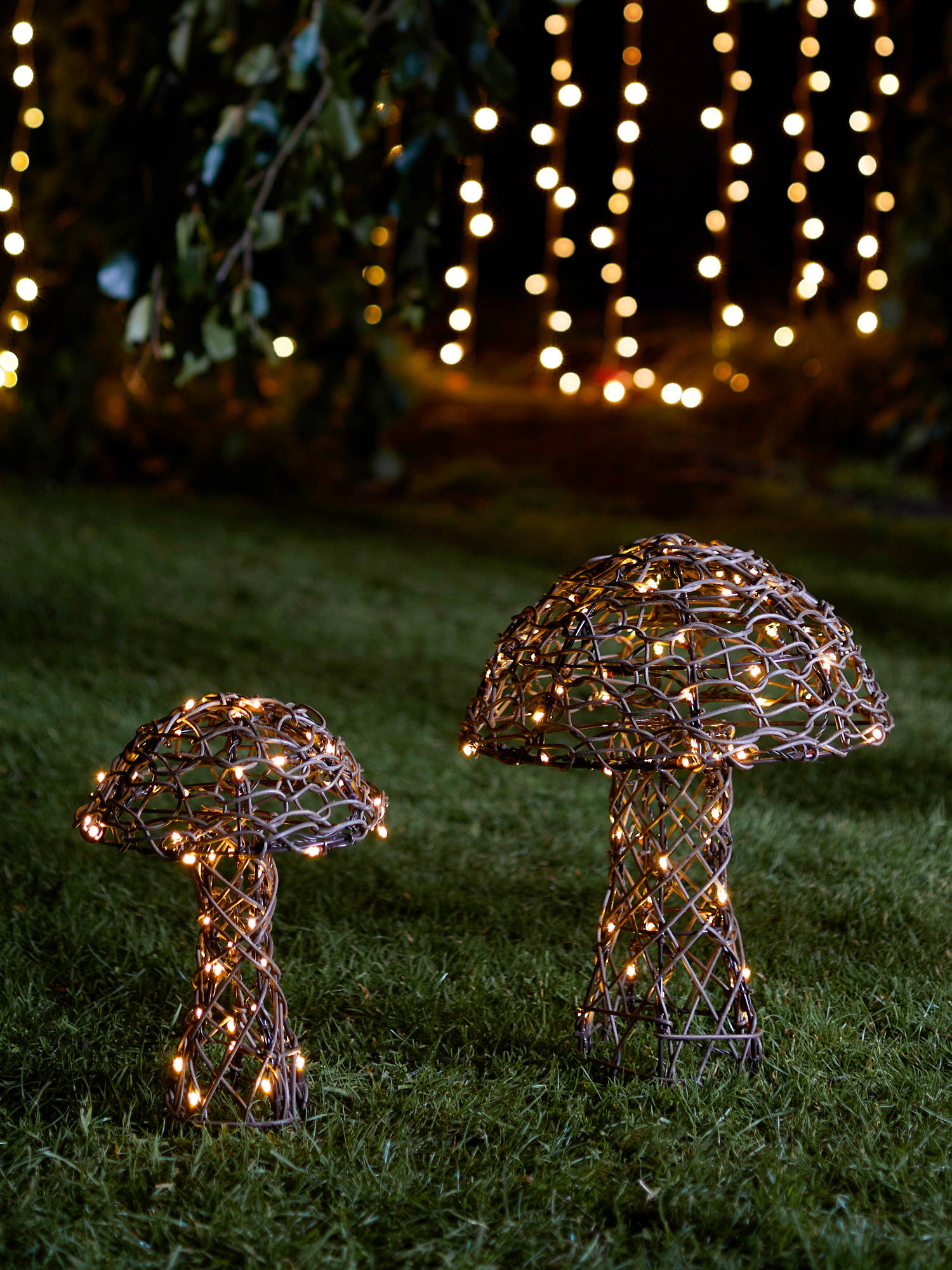 Mushroom rattan lights illuminated on lawn  