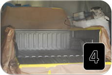 Technician applying spray-on bedliner with a low-pressure system