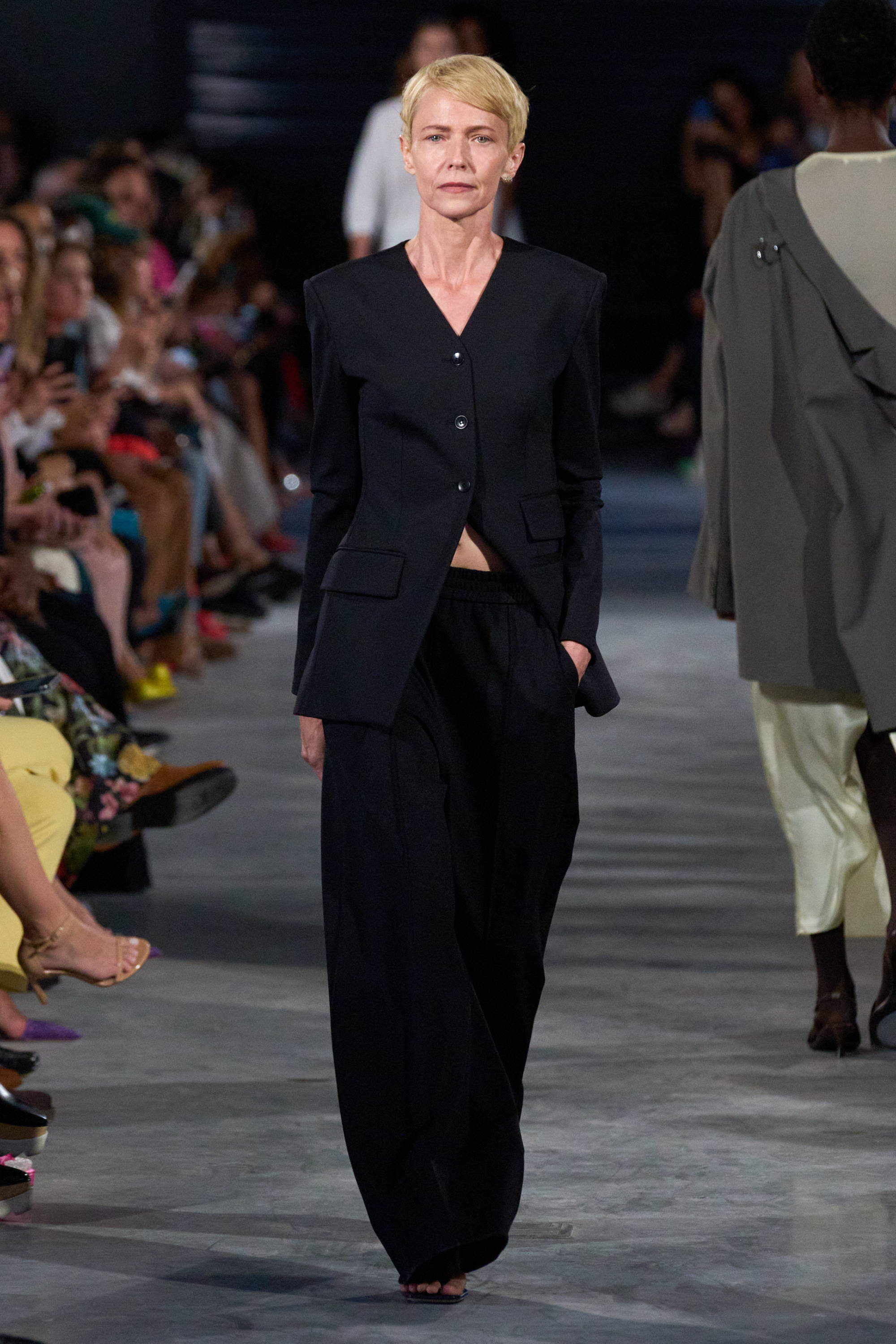 Model on a runway wearing blazer and pants