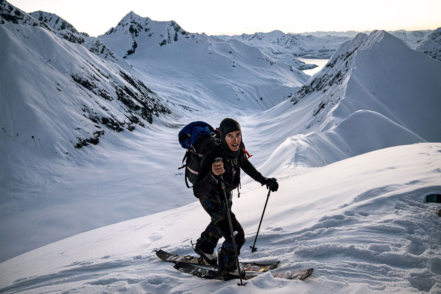 Person hiking on snow-covered mountains with a backpack.
