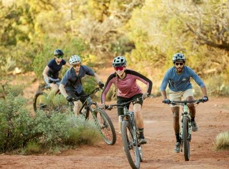 A group of people riding bikes on a dirt road