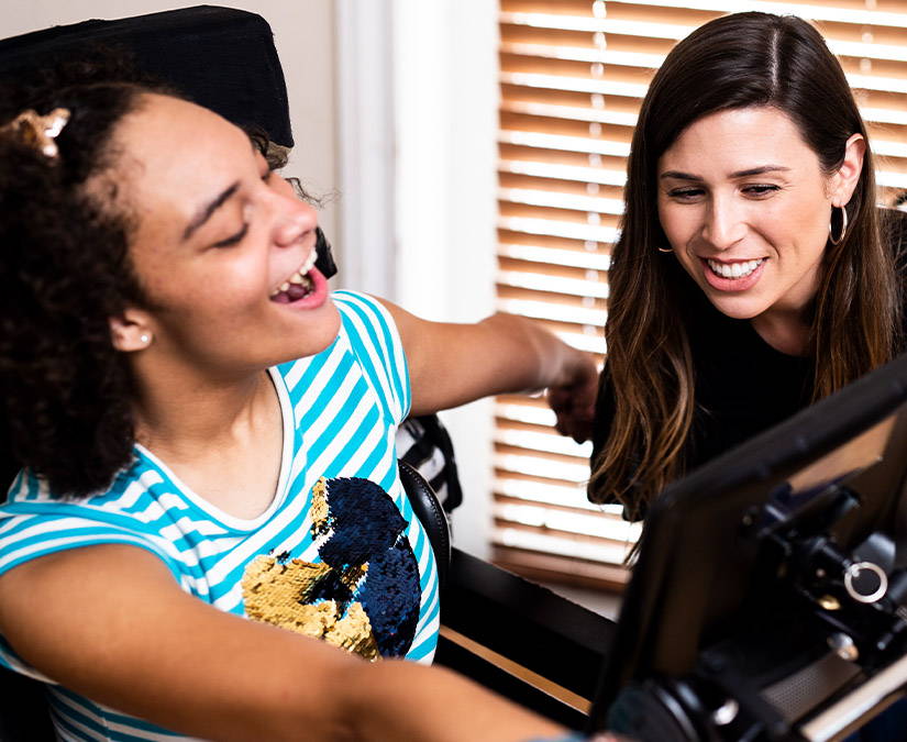 SLP helping young woman using a Tobii Dynavox SGD (speech generating device)