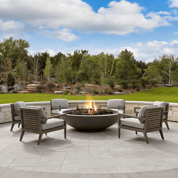 Outdoor lounge chairs arranged around a round fire pit, creating a defined fire pit seating area for backyard entertaining.