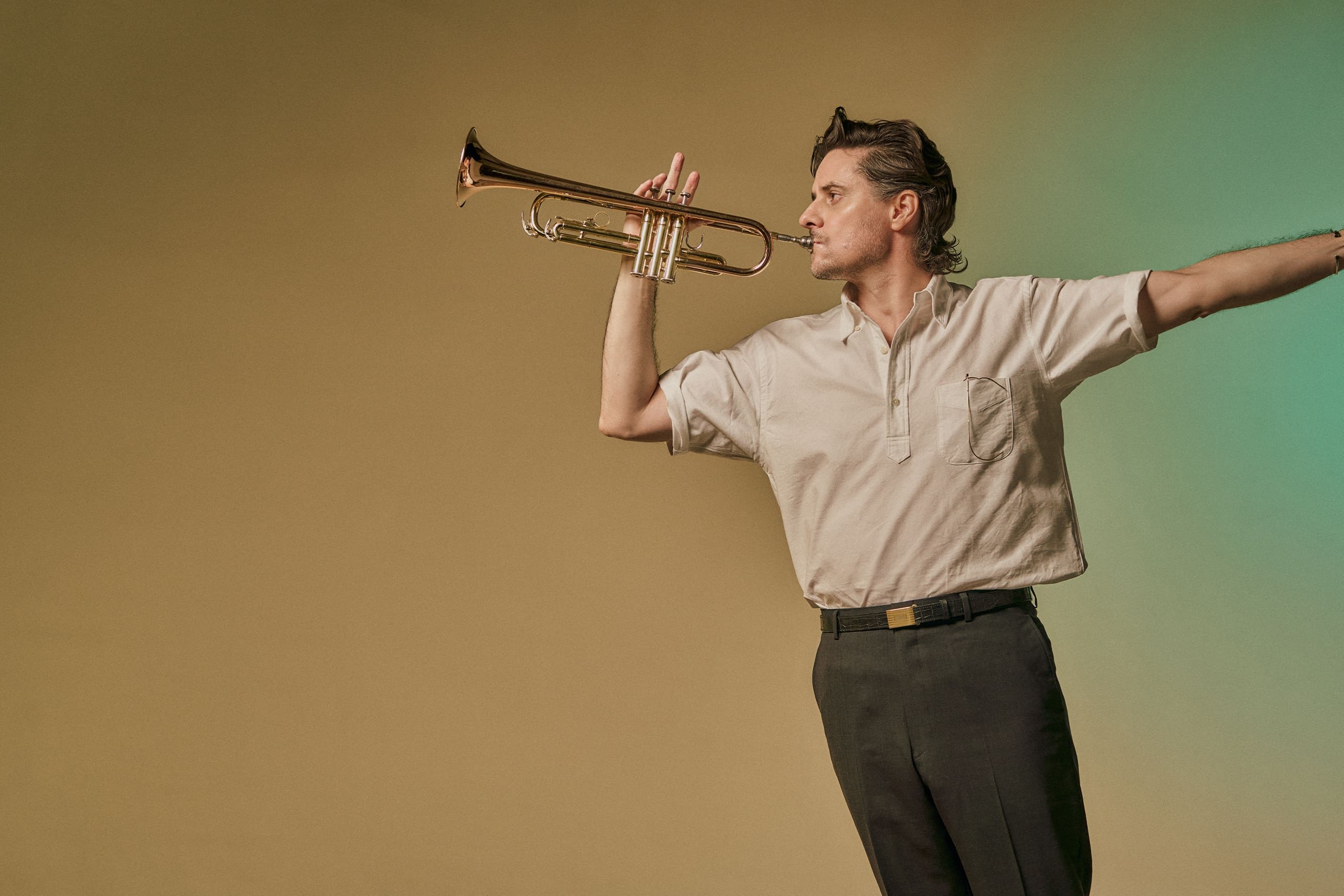 Person playing a musical instrument against a simple background.
