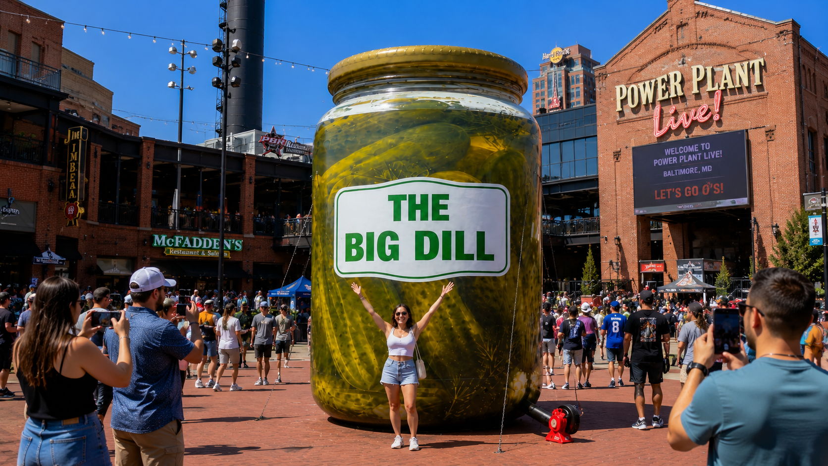 A giant pickle jar displayed in a crowd at a public event.