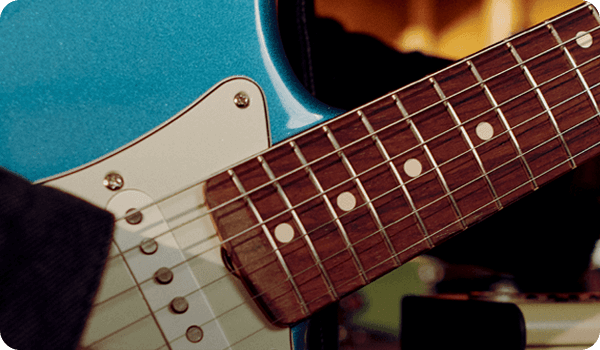 Close-up of a blue electric guitar neck and fretboard.