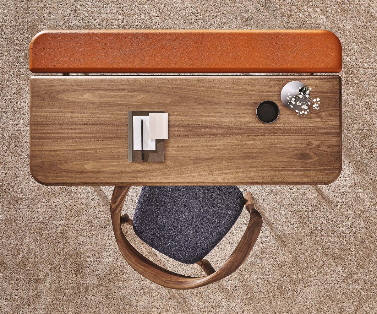 Aerial view of a wooden Aksel desk by Porada with a chair and accessories.