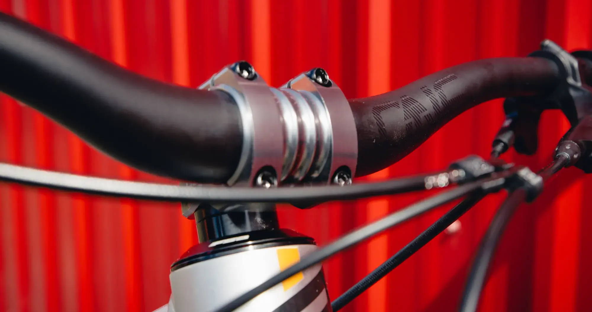 deity copperhead mountain bike stem with oneup components carbon handlebars attached from the front on a red background