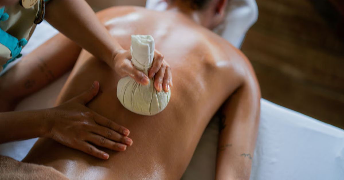 Person receiving a massage with a tool on their back.