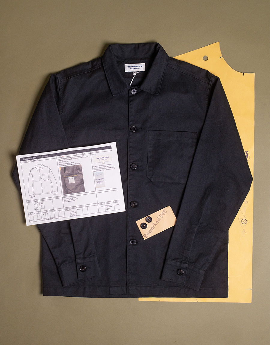 Black shirt laid on a yellow pattern sheet with tags and a document.