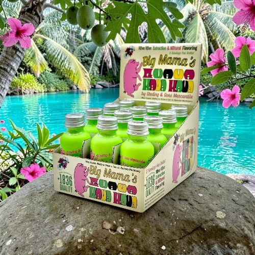 Display of green beverage bottles near a tropical pool and flowers.