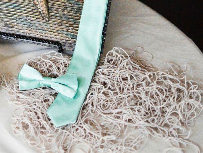 Seafoam necktie and bow tie displayed with beach themed wedding decor