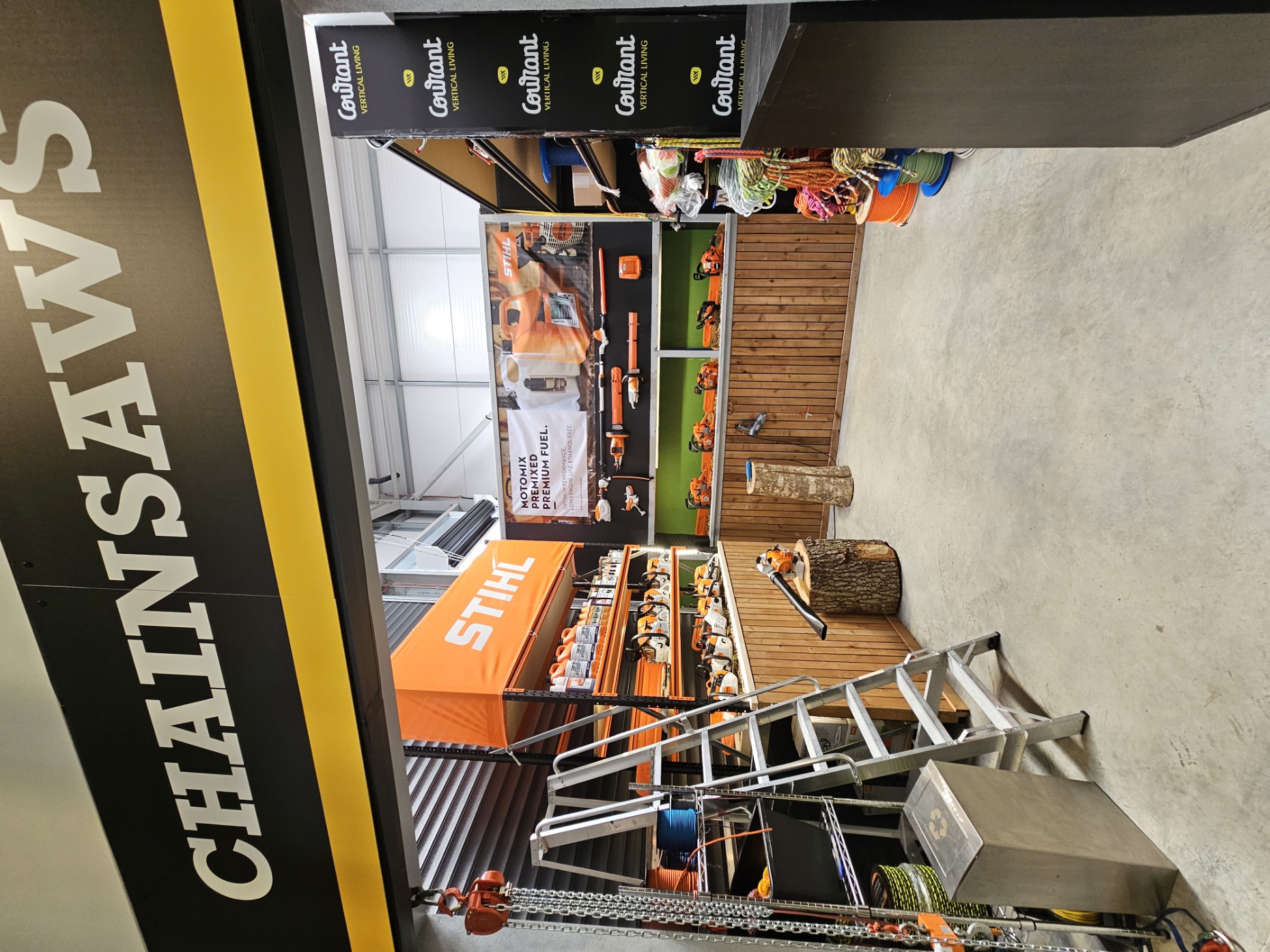 Chainsaw display area with tools, ladder, and organized shelving.