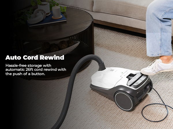 Vacuum cleaner with auto cord rewind feature on a carpeted floor.