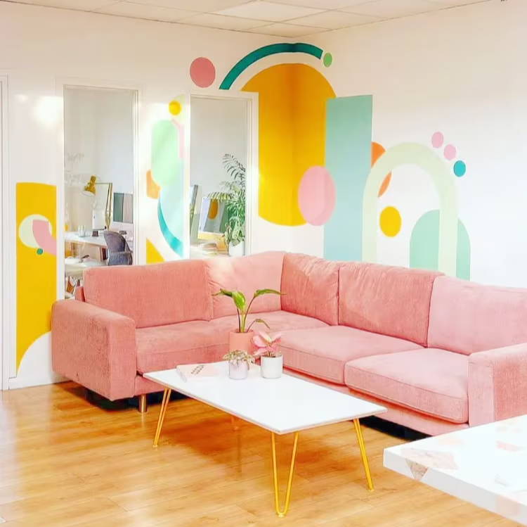 blush coral big chill corner sofa with bright abstract colour shapes painted on walls