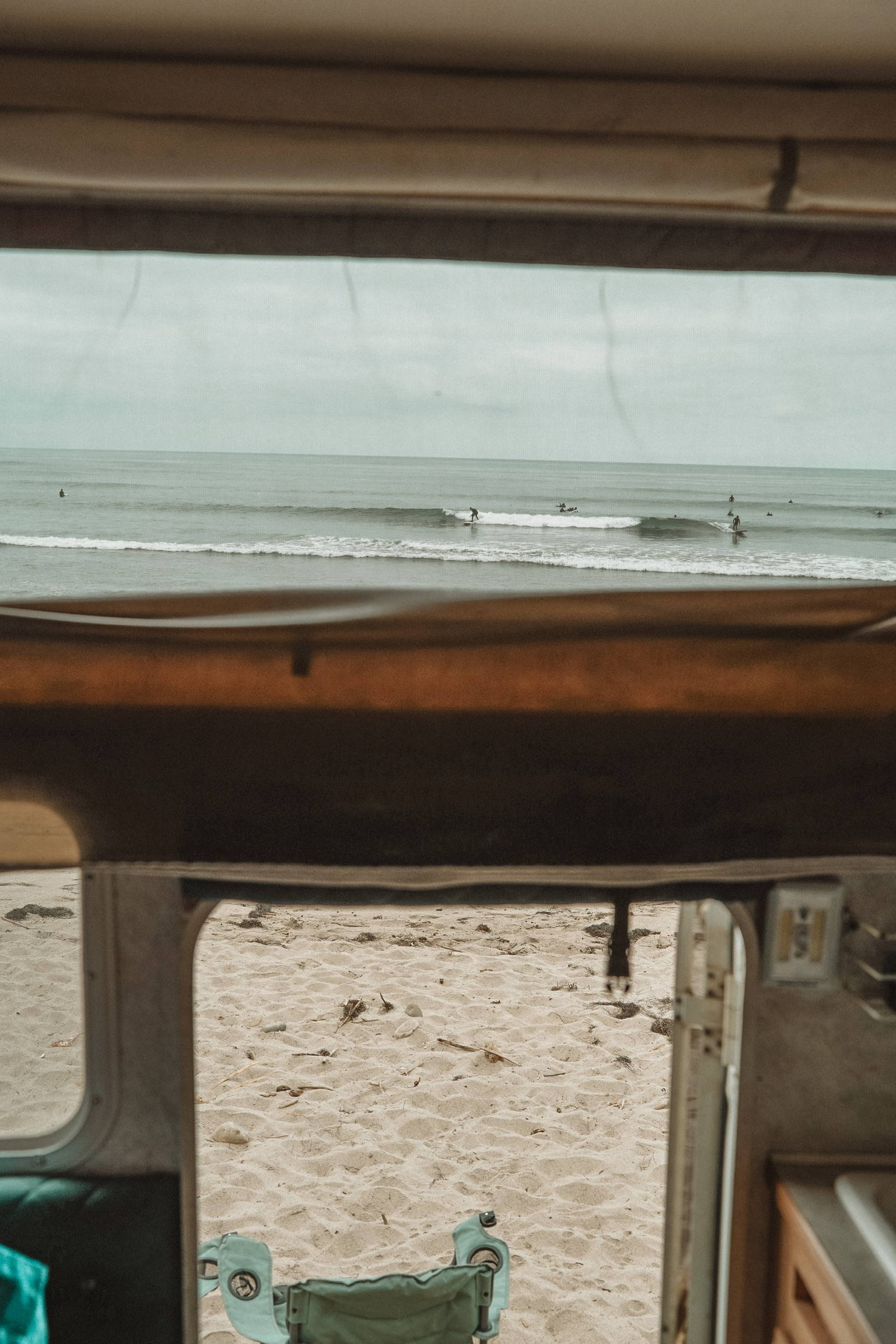 A california beach seen through the windows of a campervan