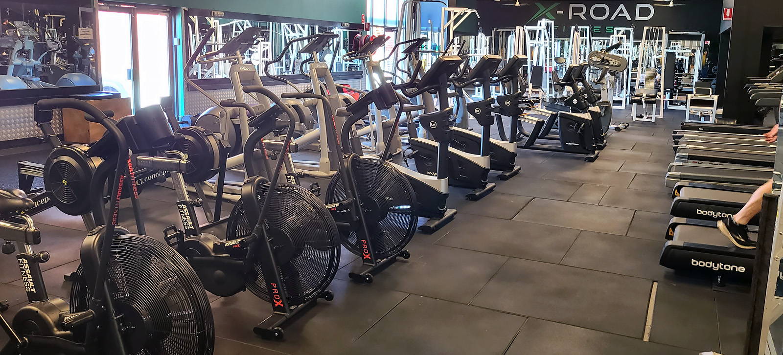 Commercial Gym Fit Oit - Spacious gym interior with a variety of modern cardio equipment including treadmills, rowing machines, and stationary bikes