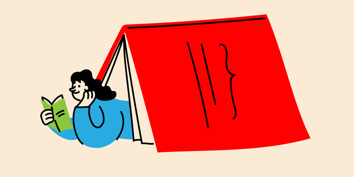 A person reading a book under a large red book tent.