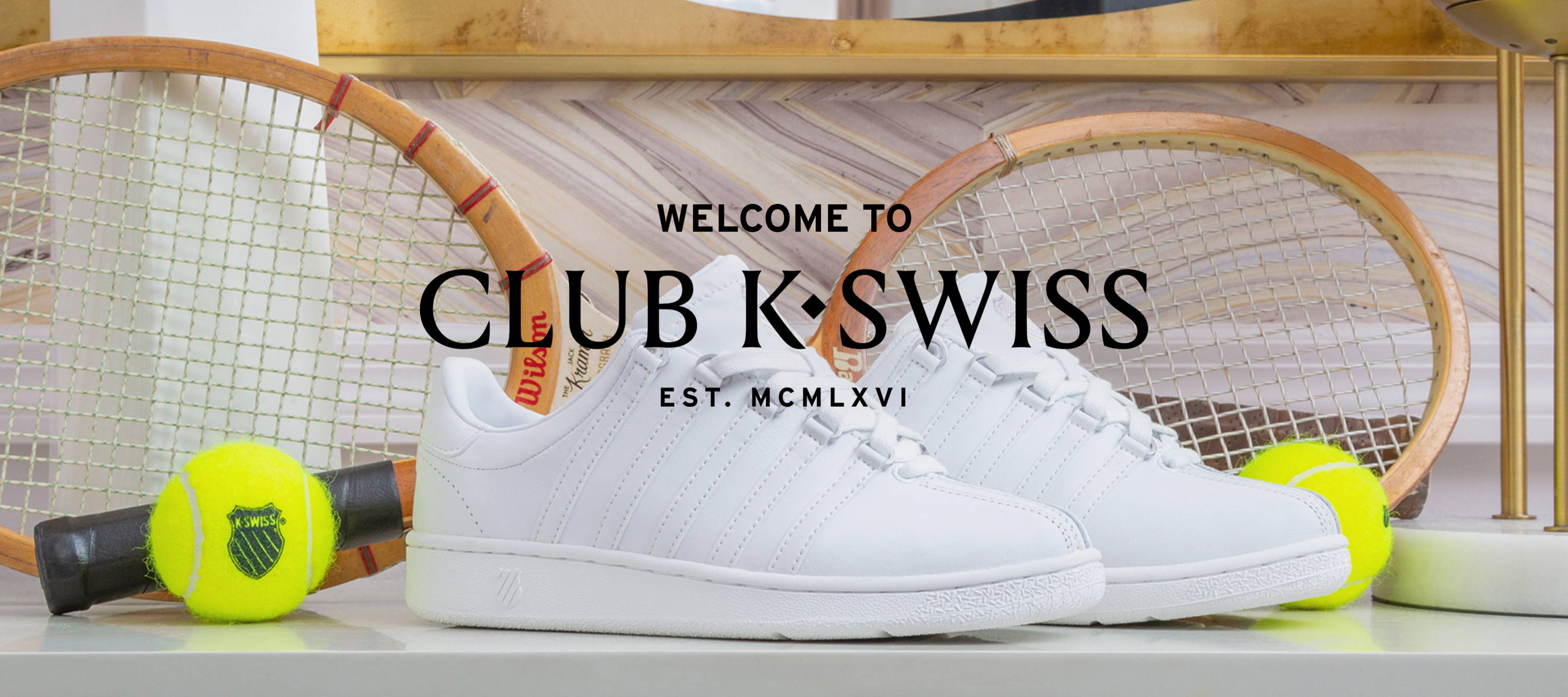 Image of White Classic VN in front of tennis rackets and tennis balls on white table. Black text over image: Welcome to Club K-Swiss EST. MCMLXVI.