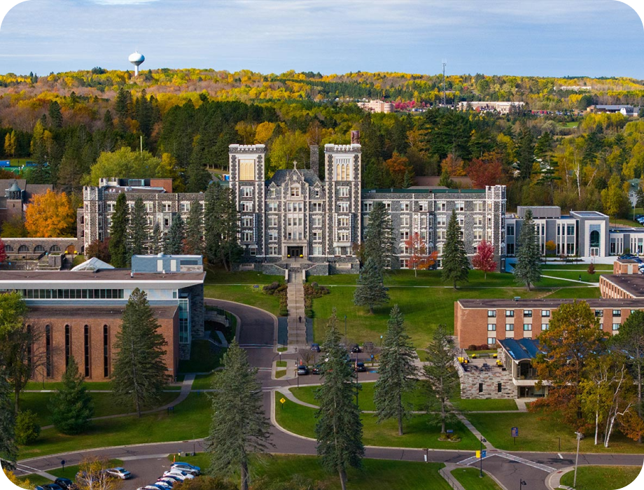 Aerial view of a university campus surrounded by trees in autumn.