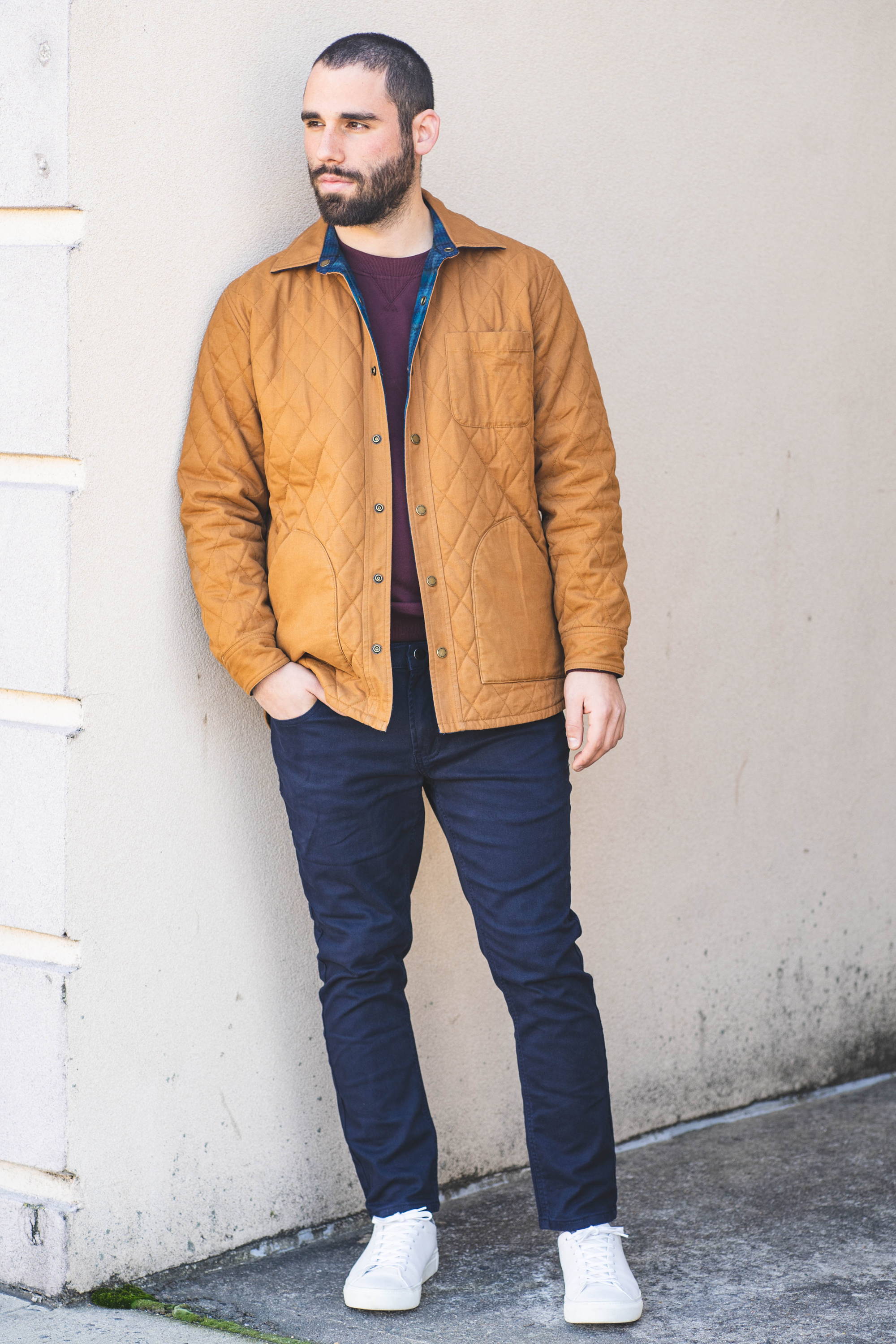 Man standing wearing a quilted tan jacket and Navy Blue Chinos from Under510.com
