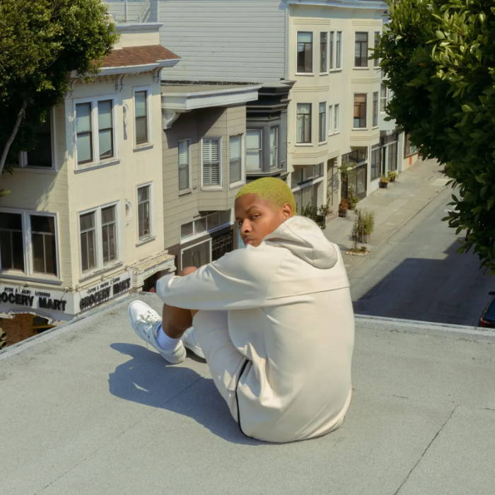 male model in cream maison article track suit on rooftop